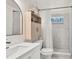 Modern bathroom featuring white vanity, large mirror, and tiled shower with storage niche at 575 E Main St, Buford, GA 30518