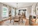 Dining room featuring a round wood table, decorative mirror, and a glimpse into the bright kitchen at 575 E Main St, Buford, GA 30518