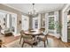 Dining room featuring a round wood table, decorative mirror, and a glimpse into the bright living room at 575 E Main St, Buford, GA 30518