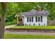 Charming home with manicured lawn, classic black shutters, and a welcoming porch with an American flag at 575 E Main St, Buford, GA 30518