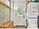 Convenient laundry area featuring stacked washer and dryer, woven basket, and patterned wallpaper at 575 E Main St, Buford, GA 30518