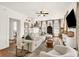 Bright living room featuring a white brick fireplace, a ceiling fan, and an oversized comfy couch at 575 E Main St, Buford, GA 30518