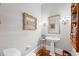 Bathroom showcases a pedestal sink, vintage mirror, and elegant sconces, blending classic design at 585 Old Cobblestone Dr, Atlanta, GA 30350