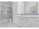 Clean bathroom with white cabinets, tiled shower, and framed mirror at 585 Old Cobblestone Dr, Atlanta, GA 30350