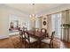 Formal dining room with a chandelier, wooden table, and views into the rest of the house at 585 Old Cobblestone Dr, Atlanta, GA 30350