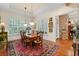 Dining room featuring a wood table, white shutters, a vintage rug, and access to other rooms at 585 Old Cobblestone Dr, Atlanta, GA 30350