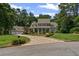 Beautiful home with lush landscaping, stone accents, and a long driveway leading to a three-car garage at 585 Old Cobblestone Dr, Atlanta, GA 30350
