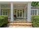 Detailed close up of the entrance to the home with stone stairs, columns and double doors at 585 Old Cobblestone Dr, Atlanta, GA 30350