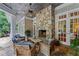 Covered outdoor space with a stone fireplace and comfortable seating at 585 Old Cobblestone Dr, Atlanta, GA 30350