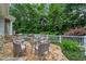 Outdoor seating area with a glass-topped table, wicker chairs, and lush landscaping creates a serene backyard retreat at 585 Old Cobblestone Dr, Atlanta, GA 30350