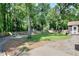 Large backyard with mature trees and a wooden fence, offering privacy and space for outdoor activities at 1379 Branchwood Dr, Snellville, GA 30078
