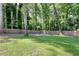 Expansive backyard with mature trees and a wooden fence, providing a private and serene outdoor space at 1379 Branchwood Dr, Snellville, GA 30078