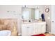 Bathroom features a double sink vanity, large mirror, tile accent wall, and separate soaking tub at 1379 Branchwood Dr, Snellville, GA 30078
