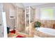 Bathroom features a tiled shower, garden tub, neutral colors, and a window allowing natural light at 1379 Branchwood Dr, Snellville, GA 30078