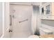 Bright bathroom featuring a walk-in shower with a grab bar and a storage cabinet above the toilet at 1379 Branchwood Dr, Snellville, GA 30078