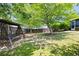 Green backyard features trees, grass, wood fence and swing under the shade of mature trees at 4527 Baker Grove Nw Rd, Acworth, GA 30101