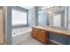 Bright bathroom with a soaking tub, granite countertop vanity, and a large window bringing in natural light at 4527 Baker Grove Nw Rd, Acworth, GA 30101