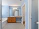A spacious bathroom features wood cabinets, granite countertops, and a white tub beneath blue walls at 4527 Baker Grove Nw Rd, Acworth, GA 30101