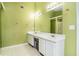 This bathroom features light green walls, a large mirror and a vanity with double sinks at 5292 Windfield Glen Nw Ct, Lilburn, GA 30047