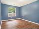 Serene bedroom with wood floors, a window offering natural light, and neutral paint for relaxation at 5292 Windfield Glen Nw Ct, Lilburn, GA 30047