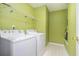 Practical laundry room with a washer, dryer, and storage shelves at 5292 Windfield Glen Nw Ct, Lilburn, GA 30047