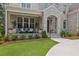 Inviting front porch featuring stone accents, cozy seating, and lush landscaping at 126 Owens Mill Pl, Canton, GA 30115