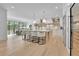Open kitchen boasts stainless appliances, wine cooler, island seating, and adjoins a dining area with exterior views at 126 Owens Mill Pl, Canton, GA 30115