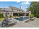 Luxury outdoor pool featuring a large patio, lounge chairs, and lush landscaping for a private backyard oasis at 126 Owens Mill Pl, Canton, GA 30115