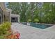 Backyard pool area with stone patio and swim up bar, surrounded by mature trees offering maximum privacy at 126 Owens Mill Pl, Canton, GA 30115