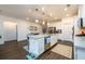 Bright kitchen featuring white cabinetry, granite countertops, an island and stainless steel appliances at 3430 Summerpoint Xing, Cumming, GA 30028