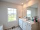 Bright bathroom with double sinks, white cabinets, and a large mirror with a window providing natural light at 6827 Chataran Dr, Lithia Springs, GA 30122