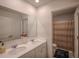 Well-lit bathroom with double sinks, decorative mirrors, and an adjacent shower with curtain at 6827 Chataran Dr, Lithia Springs, GA 30122