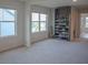 Bright bedroom with large windows, neutral carpet, and a gray storage unit for shoes at 6827 Chataran Dr, Lithia Springs, GA 30122