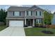 Two-story home features a brick and gray exterior, an attached garage, and a well-manicured lawn at 6827 Chataran Dr, Lithia Springs, GA 30122