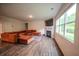 Spacious living room with a fireplace, large windows, and a comfortable orange sectional sofa at 6827 Chataran Dr, Lithia Springs, GA 30122