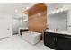 Modern bathroom featuring dual sinks, a soaking tub, wood accent wall, and a glass enclosed shower at 343 Concord St, Alpharetta, GA 30009