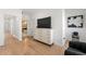 Hallway featuring a dresser with mounted TV, white walls, and hardwood floors at 343 Concord St, Alpharetta, GA 30009