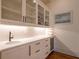 Elegant bar area includes glass-front cabinets, wine storage, sink, and plenty of counter space for entertaining at 803 Courtenay Ne Dr, Atlanta, GA 30306