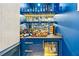 Stylish blue bar area featuring lighted shelves, plenty of bottle storage, and beverage refrigerator at 803 Courtenay Ne Dr, Atlanta, GA 30306
