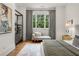Stylish bedroom featuring a cozy chaise lounge, soft lighting, and contemporary decor, creating a relaxing and inviting space at 803 Courtenay Ne Dr, Atlanta, GA 30306