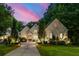 Stately home featuring professional landscape lighting, mature trees, and lush lawn at 803 Courtenay Ne Dr, Atlanta, GA 30306