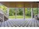 Relaxing covered patio with swing, patterned tiles, and view of the landscaped lawn at 803 Courtenay Ne Dr, Atlanta, GA 30306