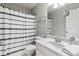 Neutral bathroom featuring a white sink, toilet, shower with curtain, and shelving unit at 113 Regent Pl, Woodstock, GA 30188