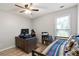 Well-lit bedroom with a ceiling fan, hardwood floors, desk, shelving, and window at 113 Regent Pl, Woodstock, GA 30188