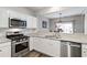 Bright kitchen with white cabinets, stainless appliances, and granite countertops at 113 Regent Pl, Woodstock, GA 30188