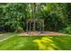 Charming backyard featuring a swing set, lush artificial turf, and mature trees, perfect for Gathering fun at 1753 Russell Se St, Atlanta, GA 30316