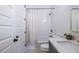 Cozy bathroom features gray cabinets, a shower with a decorative curtain, and dual doors at 1753 Russell Se St, Atlanta, GA 30316