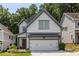Stylish two-story home boasts white siding, gray accents, a two-car garage, and a welcoming front yard with greenery at 1753 Russell Se St, Atlanta, GA 30316