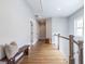 Well-lit hallway featuring hardwood floors, a bench, and railing at 1753 Russell Se St, Atlanta, GA 30316