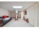 Large basement area with plush carpet, overhead lighting, closet space, and a dark leather couch at 4440 Weston Sw Dr, Lilburn, GA 30047